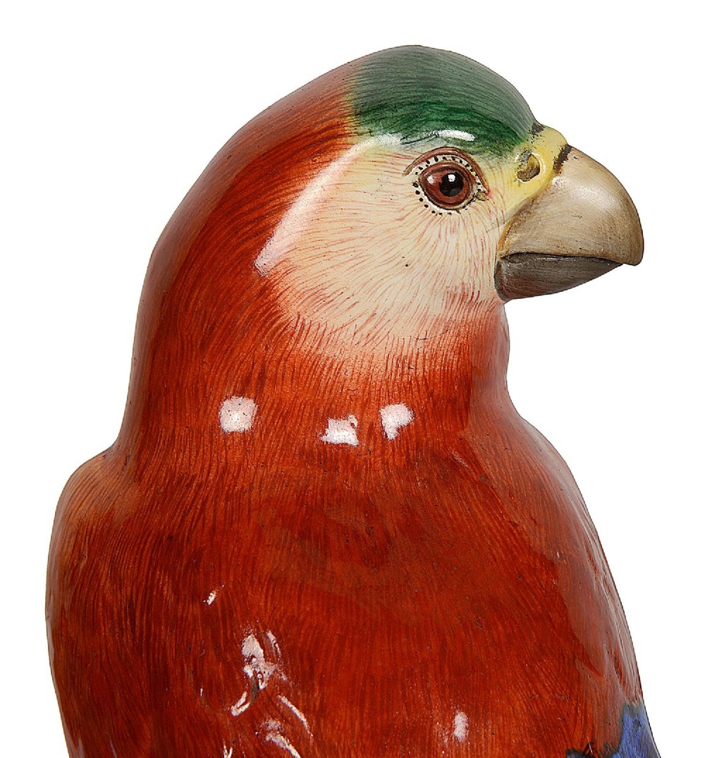 A pair of late 19th-century Meissen porcelain parrots with brightly coloured plumage perched on sculpted tree stump bases. View V