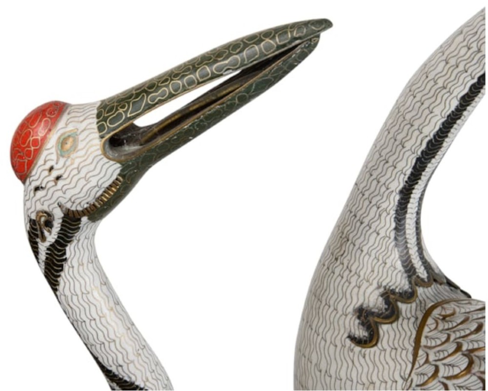 A pair of Chinese cloisonne crane sculptures crafted with white enamel bodies standing on patterned blue bases. View V