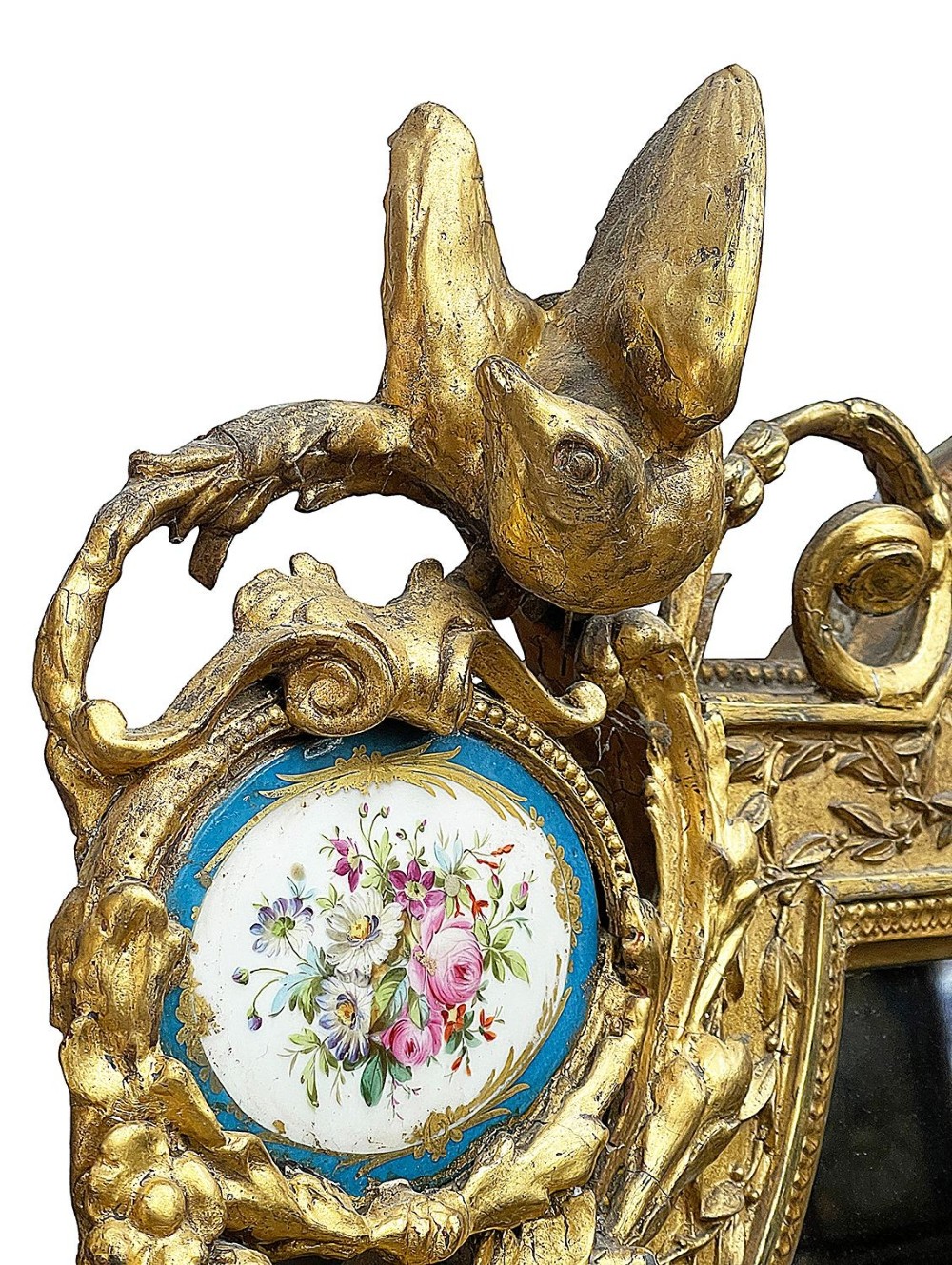 A large gilt-bronze wall mirror featuring an arched crest with sculpted putti, foliage mouldings, and oval Sevres porcelain plaques set along the frame. View III