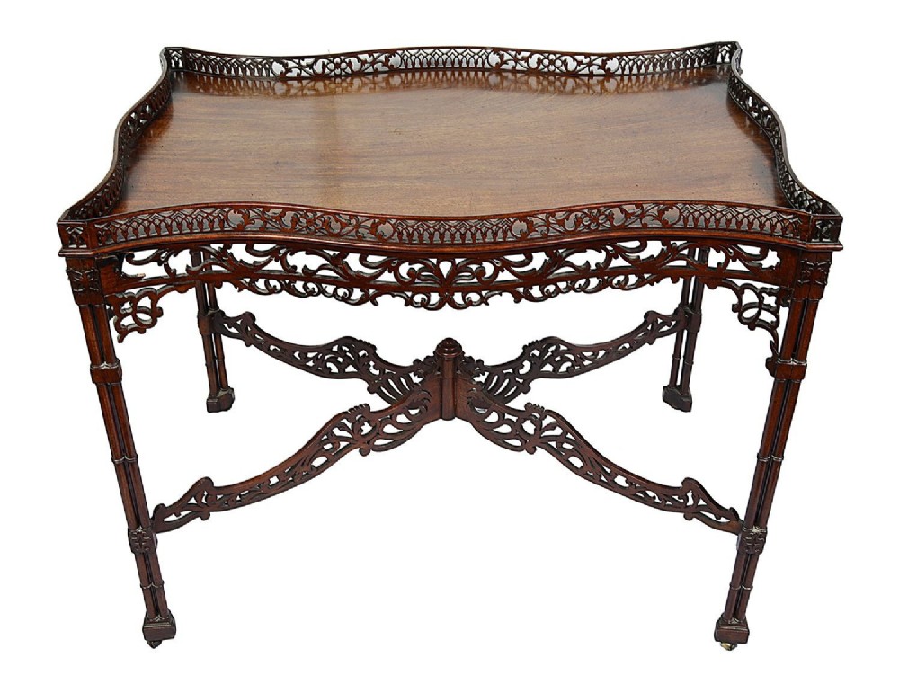 A dark mahogany Chippendale style silver table featuring a serpentine top, pierced fretwork gallery, pierced apron, and cluster legs with an X-stretcher. View II