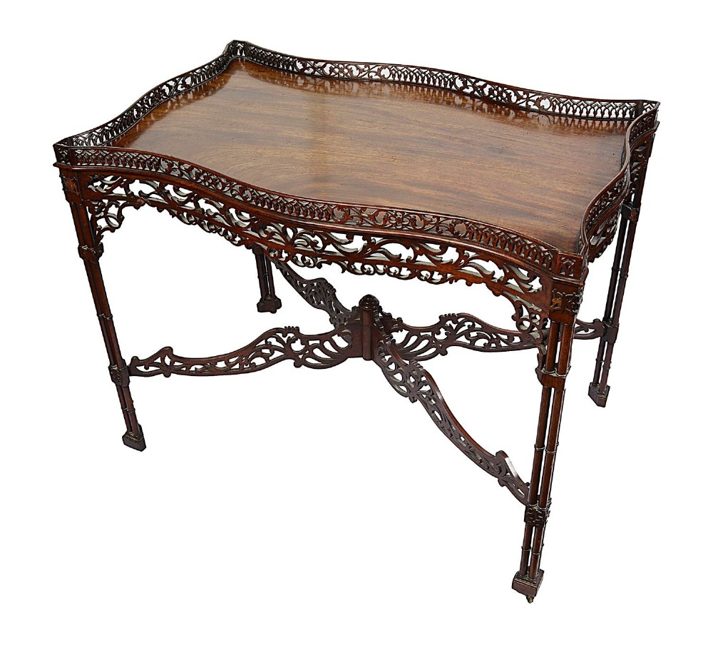 A dark mahogany Chippendale style silver table featuring a serpentine top, pierced fretwork gallery, pierced apron, and cluster legs with an X-stretcher. View VII