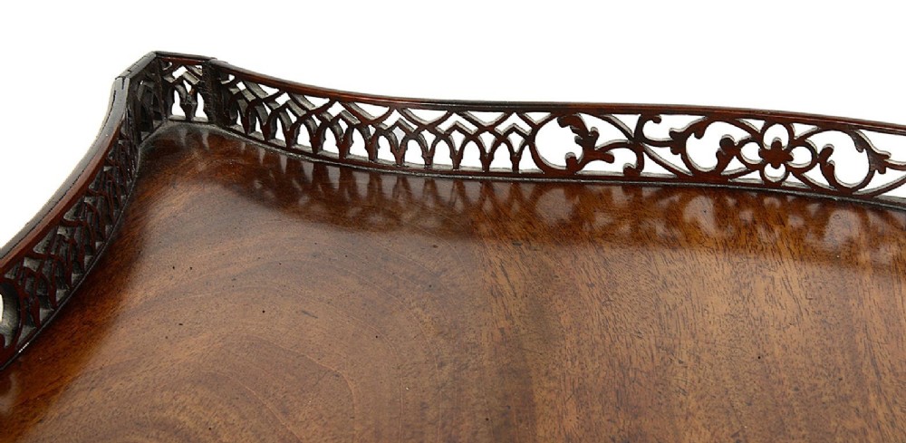 A dark mahogany Chippendale style silver table featuring a serpentine top, pierced fretwork gallery, pierced apron, and cluster legs with an X-stretcher. View VIII