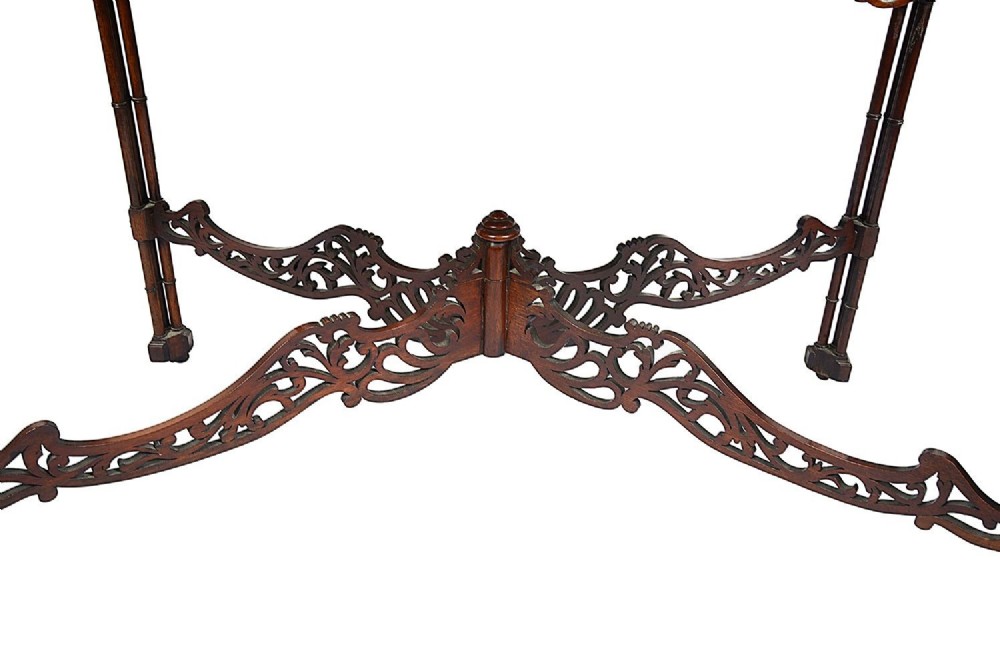 A dark mahogany Chippendale style silver table featuring a serpentine top, pierced fretwork gallery, pierced apron, and cluster legs with an X-stretcher. View XI