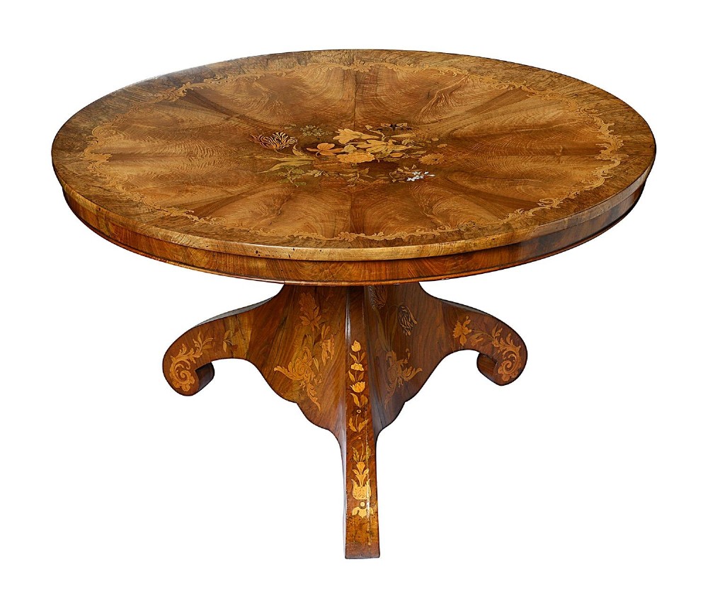 A circular Victorian walnut centre table featuring radial segment veneers, intricate floral marquetry, and a carved pedestal base with scroll feet. View IV