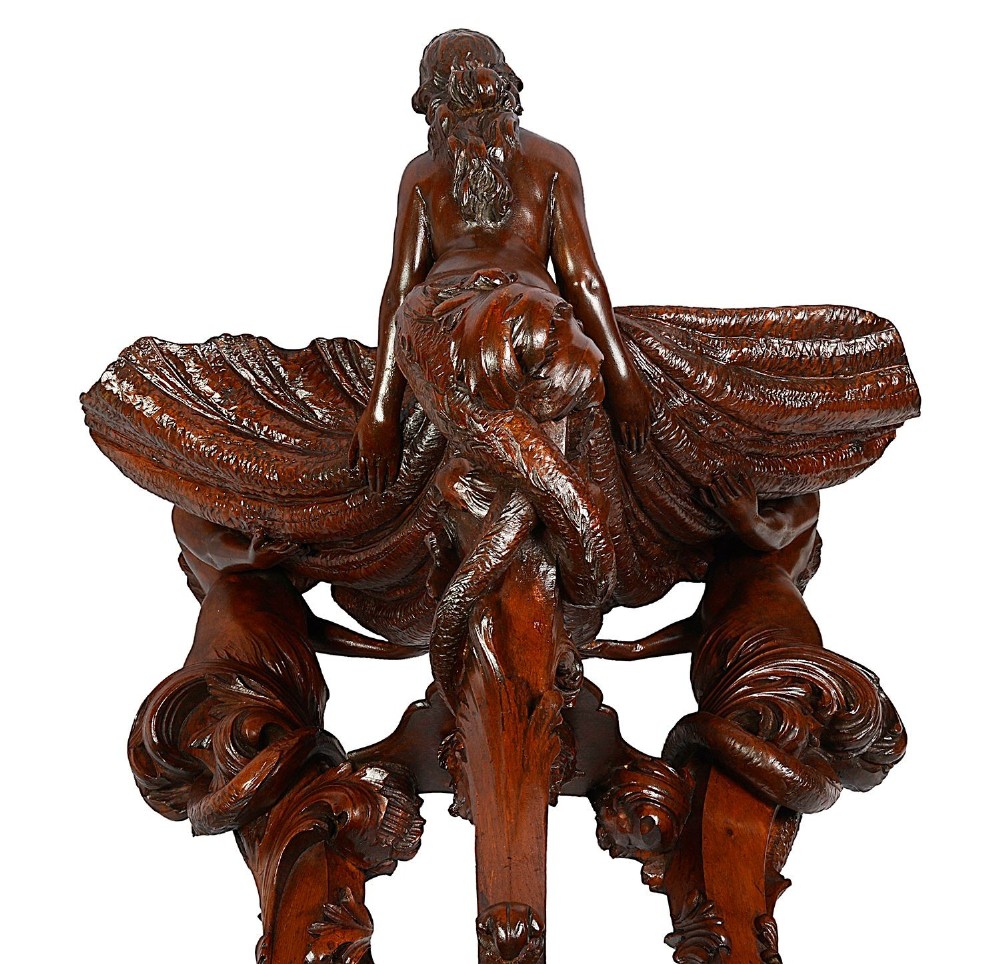 An 18th-century style carved walnut jardiniere featuring three mythical figures supporting a large shell basin on a tripod base. View IX