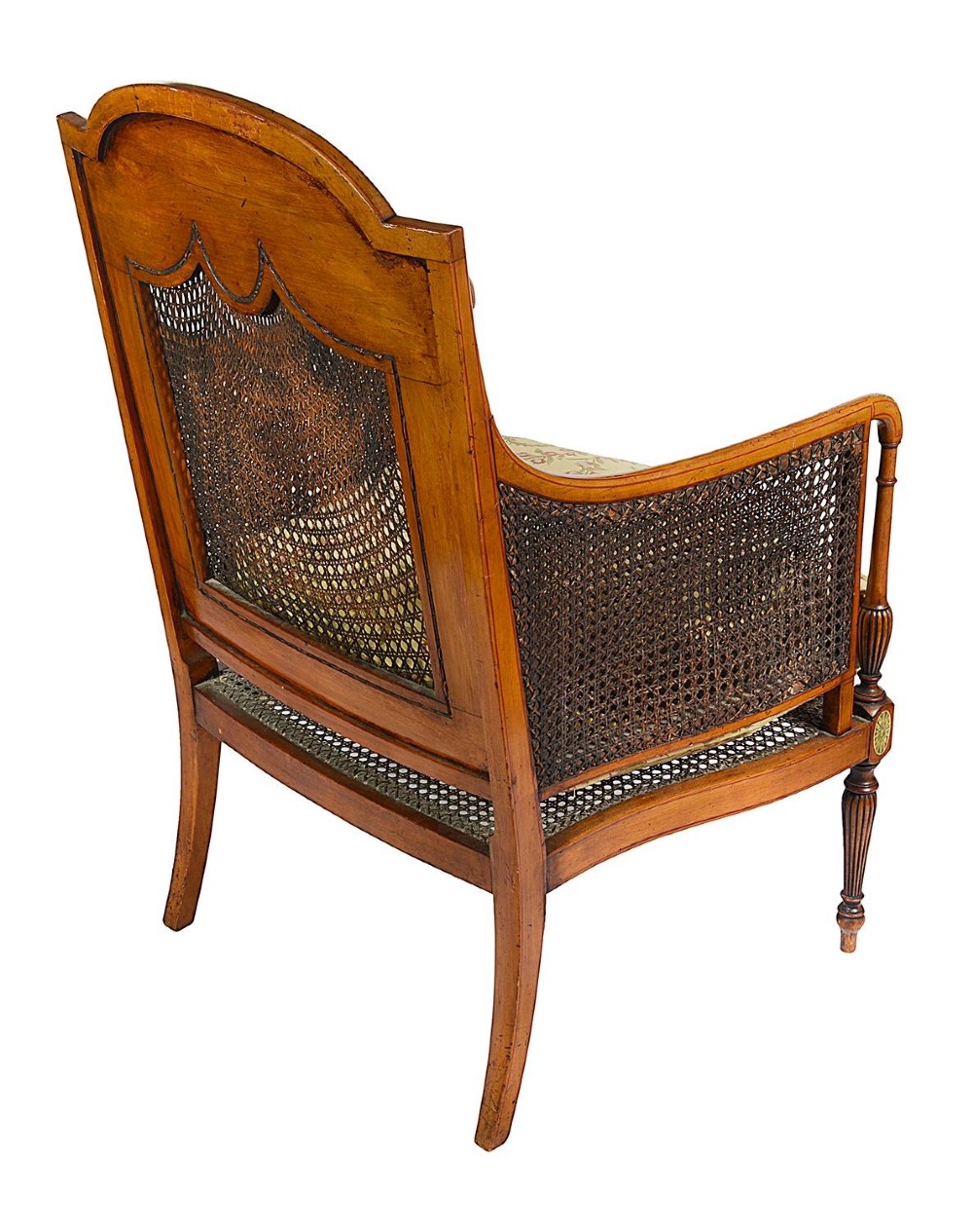 A pair of late Victorian Sheraton Revival satinwood bergere armchairs featuring hand-painted floral motifs, portrait medallions, caned backs, and yellow fabric seats. View X