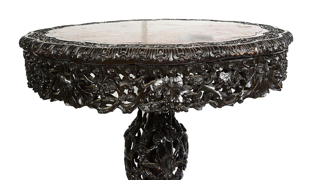 A nineteenth-century Chinese carved dark hardwood side table featuring a circular pink marble inset top, pierced openwork frieze, reticulated central pedestal, and tripod clawed feet. View IV