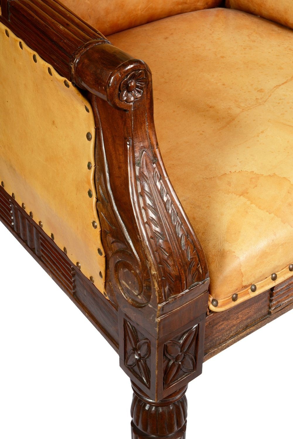 A pair of Regency style dark mahogany library armchairs upholstered in tan leather with brass stud trimming and reeded carved legs. View IV
