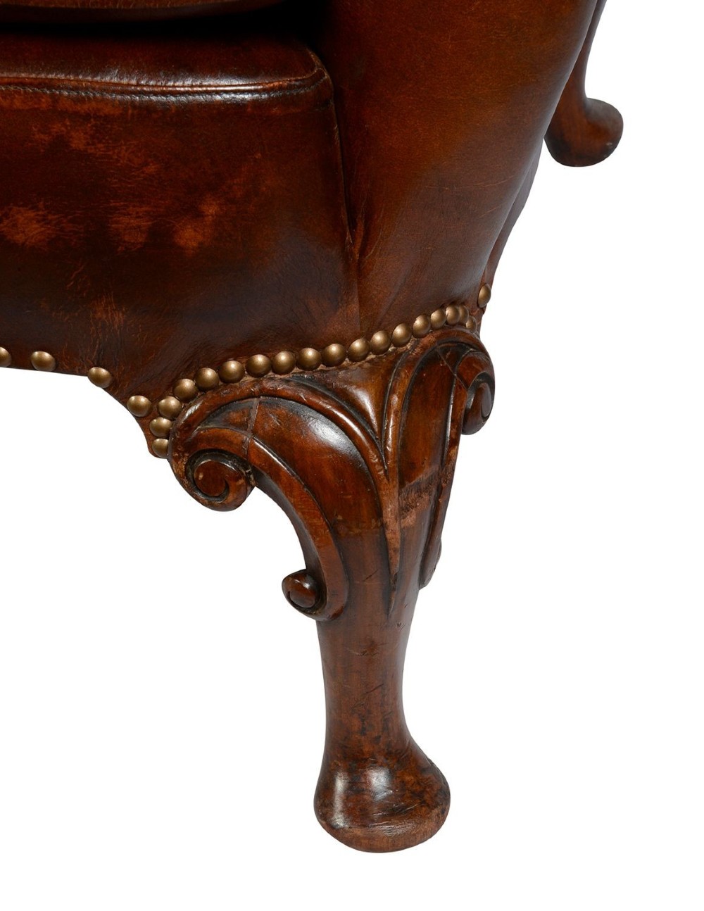 A pair of Georgian style chestnut brown leather wingback armchairs featuring deep button tufting, brass stud trimming, and carved cabriole legs. View VII