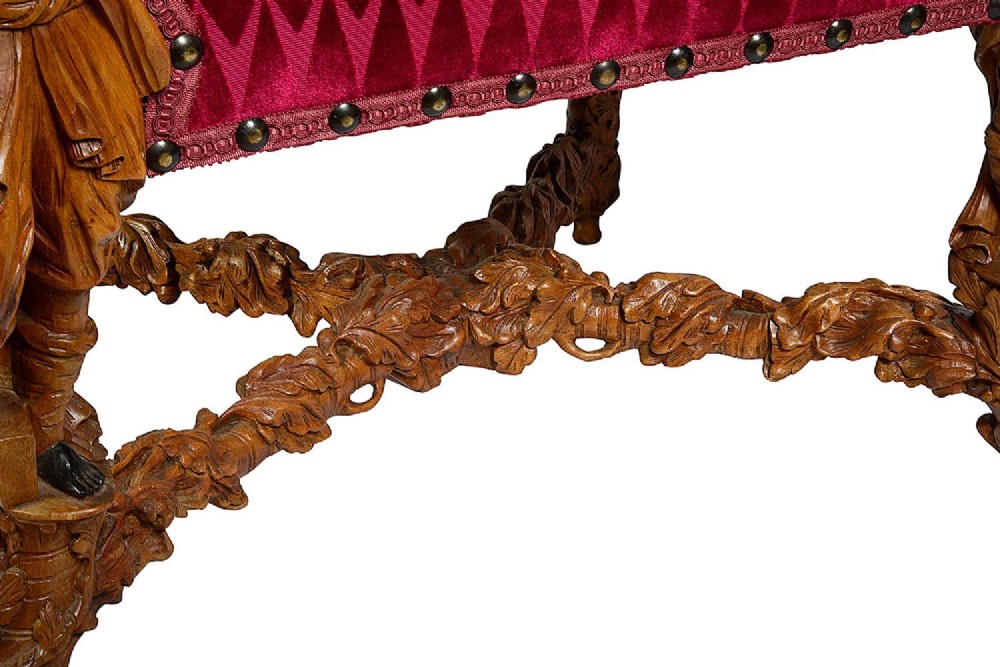 An ornate Venetian style armchair with high back red diamond velvet upholstery and detailed carved wooden human figures forming the armrests and legs. View IX