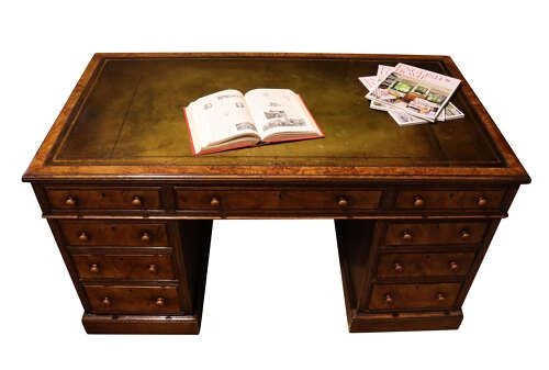 fig 1. A Victorian oak and burr walnut pedestal desk featuring nine drawers with turned wooden knob handles and a central kneehole.