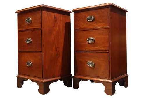 fig 1. A pair of Victorian mahogany bedside chests featuring three drawers each, brass oval handles, and shaped bracket feet.