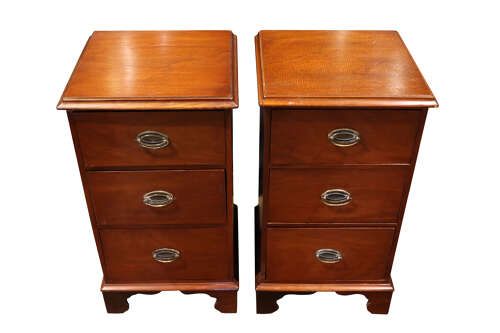 fig 2. A pair of Victorian mahogany bedside chests featuring three drawers each, brass oval handles, and shaped bracket feet.