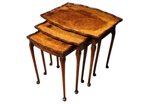 fig 1. A set of three nested 1920s burr walnut side tables featuring shaped piecrust tops and slender cabriole legs.