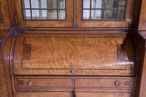 fig 4. A Regency mahogany breakfront secretaire bookcase with glazed doors, satinwood veneers, and ebony inlay detail.