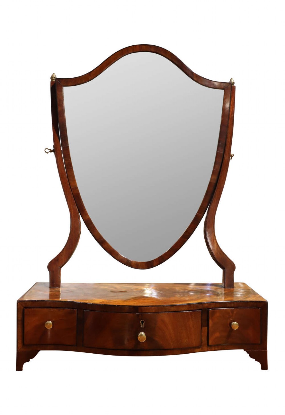 An early nineteenth-century mahogany dressing table mirror featuring a shield-shaped frame supported by curved uprights over a bowfront base with three drawers.
