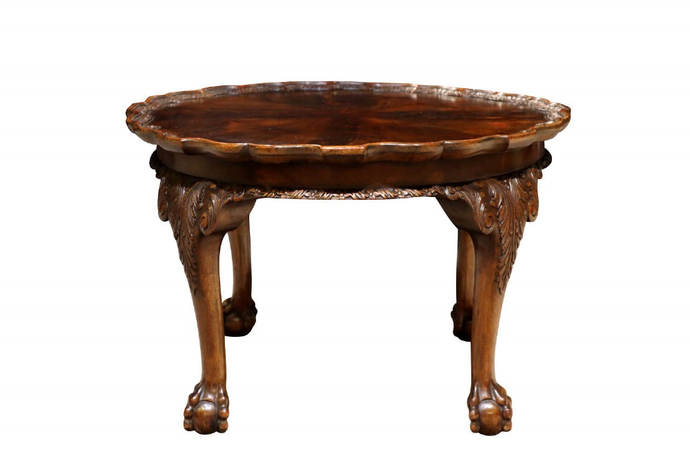 A low circular burr walnut occasional table featuring a scalloped piecrust rim, carved cabriole legs, and ball-and-claw feet.