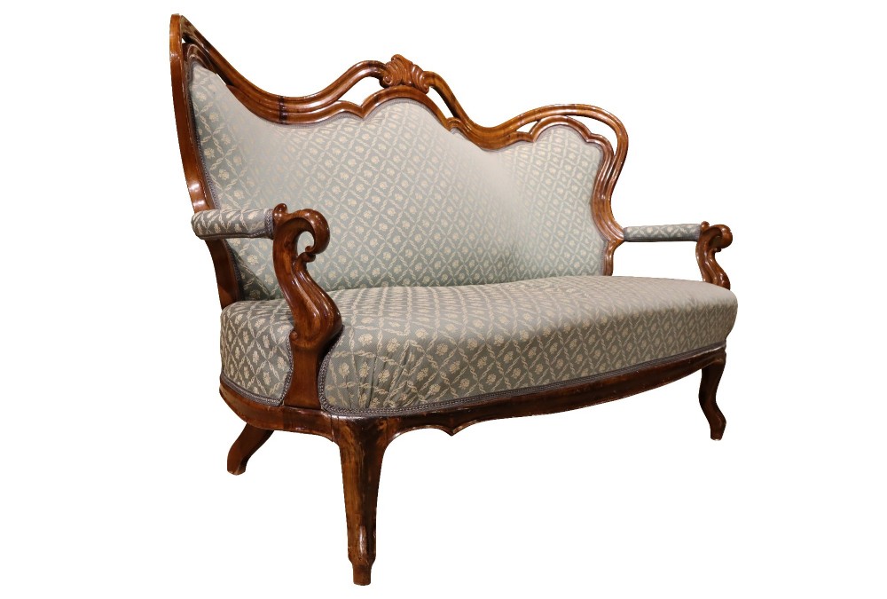 A late 19th-century three-piece walnut salon suite featuring a central settee and two matching armchairs upholstered in patterned sage green fabric with carved serpentine frames. View V