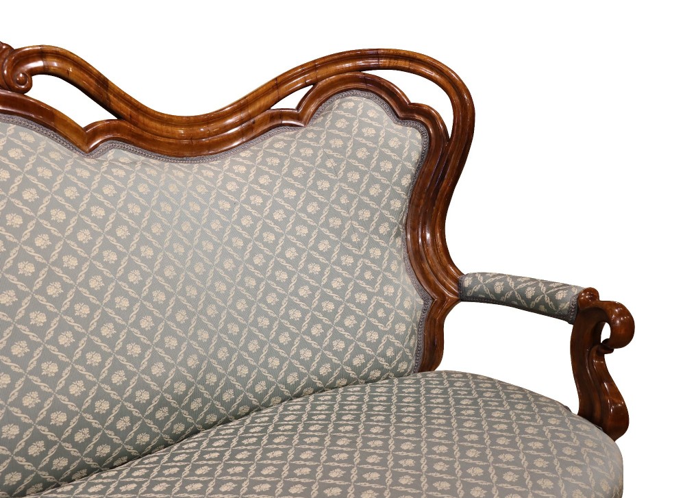 A late 19th-century three-piece walnut salon suite featuring a central settee and two matching armchairs upholstered in patterned sage green fabric with carved serpentine frames. View VI