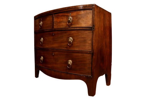 A George III bow-fronted mahogany chest of drawers featuring two short over two long drawers with brass lion mask ring handles and splayed feet. View II