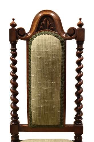 A Victorian walnut childs chair featuring spiralled barley twist uprights, a carved top crest, an upholstered green fabric seat and back, and a shaped front stretcher. View V