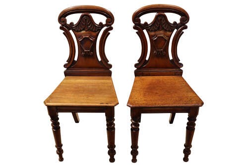 A pair of mid-Victorian mahogany hall chairs with carved shield backrests, solid seats, and turned front legs. View III