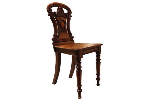 A pair of mid-Victorian mahogany hall chairs with carved shield backrests, solid seats, and turned front legs. View VI