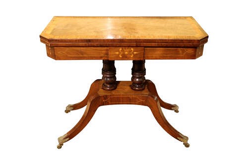 A Regency period rosewood foldover card table featuring marquetry inlay, twin turned pedestals, and four curved legs with brass sabots and castors. View V
