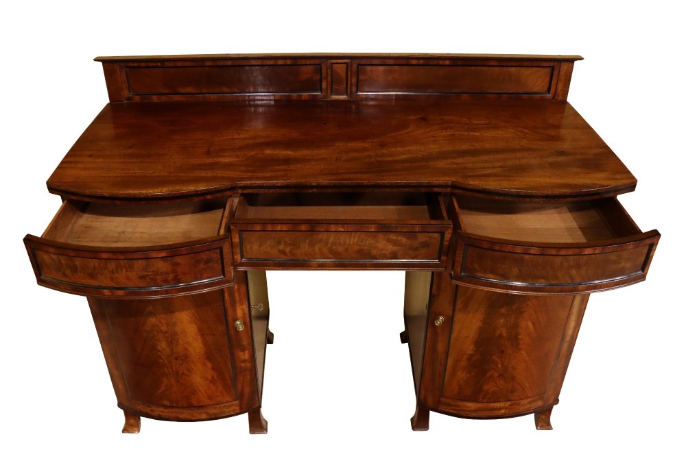 An early 19th-century Regency flame mahogany bow-front pedestal sideboard with twin cupboard doors, a central drawer, and a low rear gallery. View VI