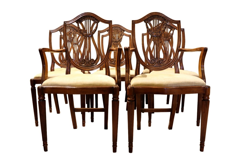Set of mahogany dining chairs featuring shield-shaped backs with carved lyre motifs, fluted front legs, and neutral upholstered seats. View II