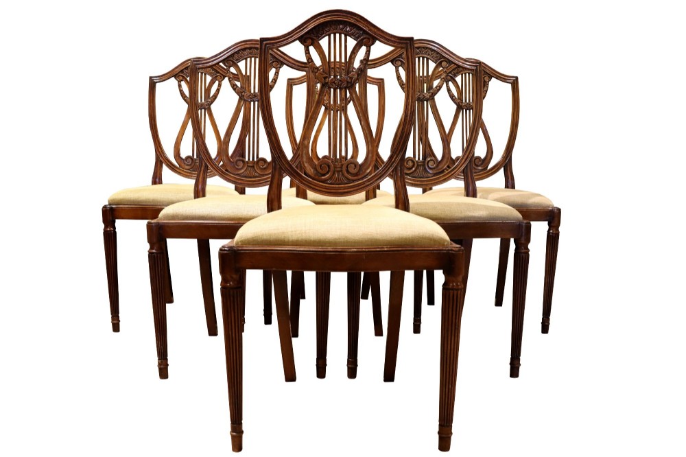 Set of mahogany dining chairs featuring shield-shaped backs with carved lyre motifs, fluted front legs, and neutral upholstered seats. View III