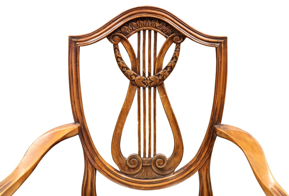 Set of mahogany dining chairs featuring shield-shaped backs with carved lyre motifs, fluted front legs, and neutral upholstered seats. View VIII