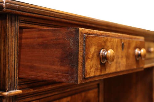 A Victorian oak and burr walnut pedestal desk featuring nine drawers with turned wooden knob handles and a central kneehole. View VIII