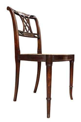An Edwardian dark mahogany side chair featuring a woven cane seat, pierced lattice splat, and turned front legs. View III