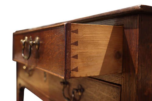 A George III dark oak lowboy featuring a rectangular top over three drawers with brass swan-neck handles, supported on straight square legs. View VI