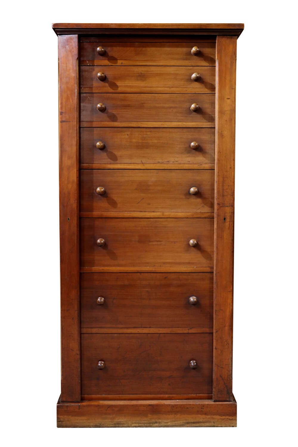 A tall mid-19th century mahogany Wellington chest featuring eight graduated drawers with turned wooden knobs and a side-locking hinged pilaster.