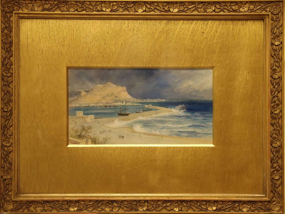 A 19th-century framed watercolour painting depicting Palermo harbour in Sicily with waves breaking against a breakwater beneath a mountain peak.