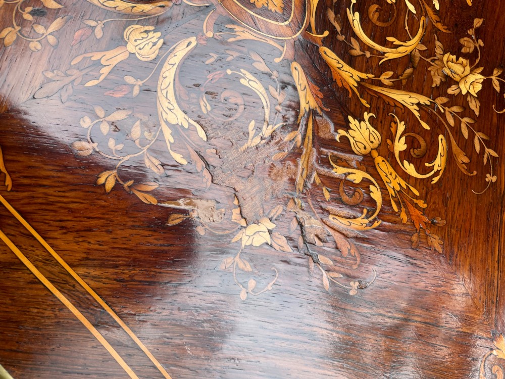 A late 19th-century French marquetry sewing table featuring floral wood inlay on a serpentine top, brass edging, and slender cabriole legs. View V