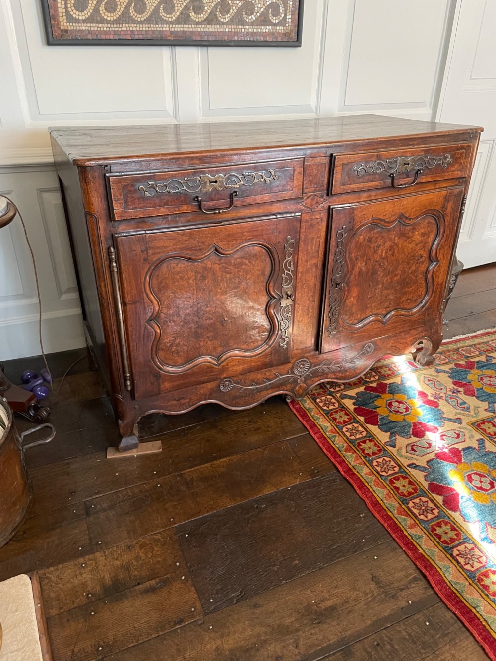 An 18th-century French walnut buffet featuring two upper drawers above two moulded panel doors with brass escutcheons and a carved apron.