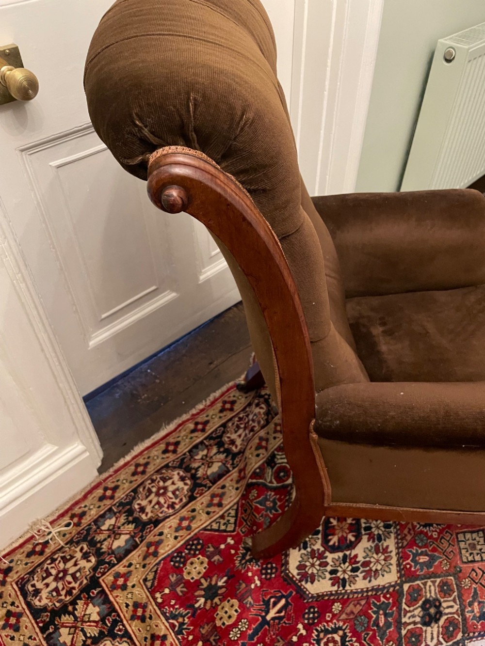 A Victorian mahogany library chair featuring dark brown velvet button-tufted upholstery, carved scroll arms, and brass castors. View II