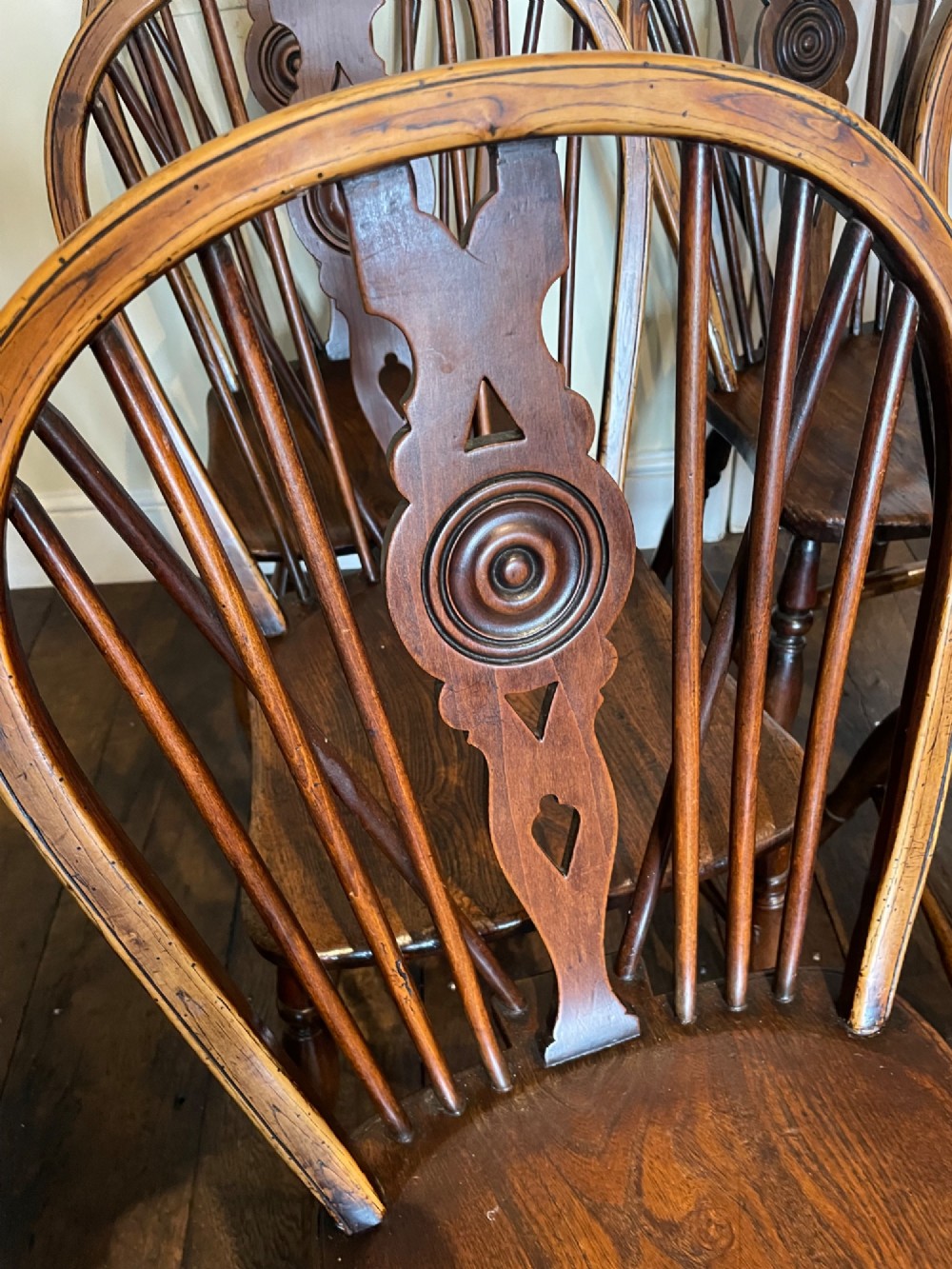 A set of six warm brown elm wheelback dining chairs featuring hoop backs, carved central splats, and turned legs. View II