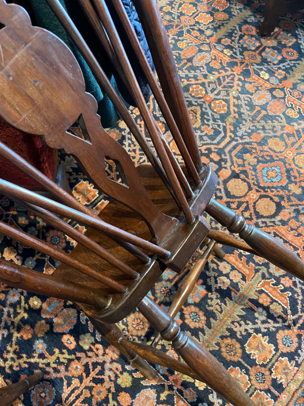 A set of six warm brown elm wheelback dining chairs featuring hoop backs, carved central splats, and turned legs. View III