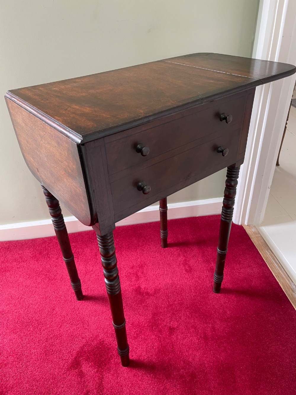 A dark mahogany drop-leaf side table featuring two drawers with wooden knobs and four slender turned legs. View IV