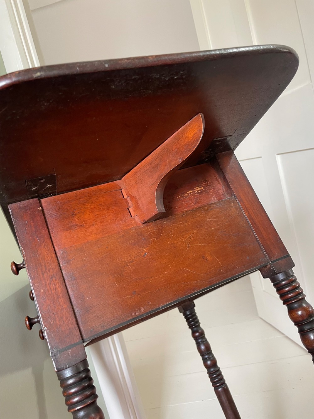 A dark mahogany drop-leaf side table featuring two drawers with wooden knobs and four slender turned legs. View V