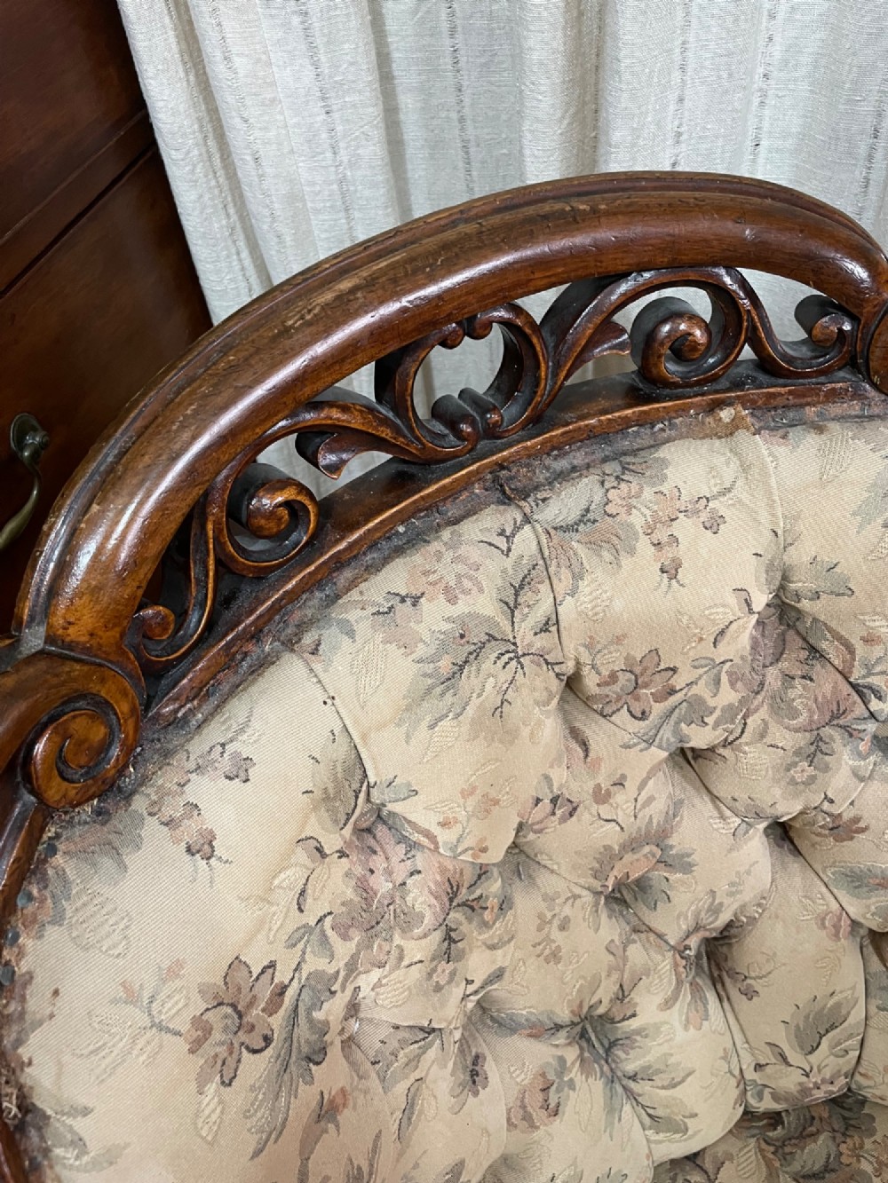 A Victorian carved walnut armchair featuring button-tufted floral fabric upholstery, curved armrests, and cabriole legs on brass castors. View II