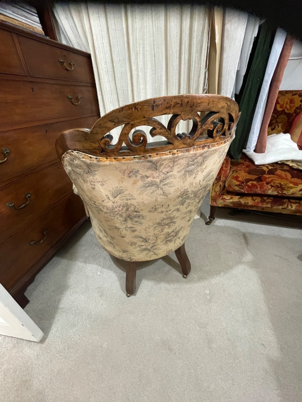A Victorian carved walnut armchair featuring button-tufted floral fabric upholstery, curved armrests, and cabriole legs on brass castors. View IV