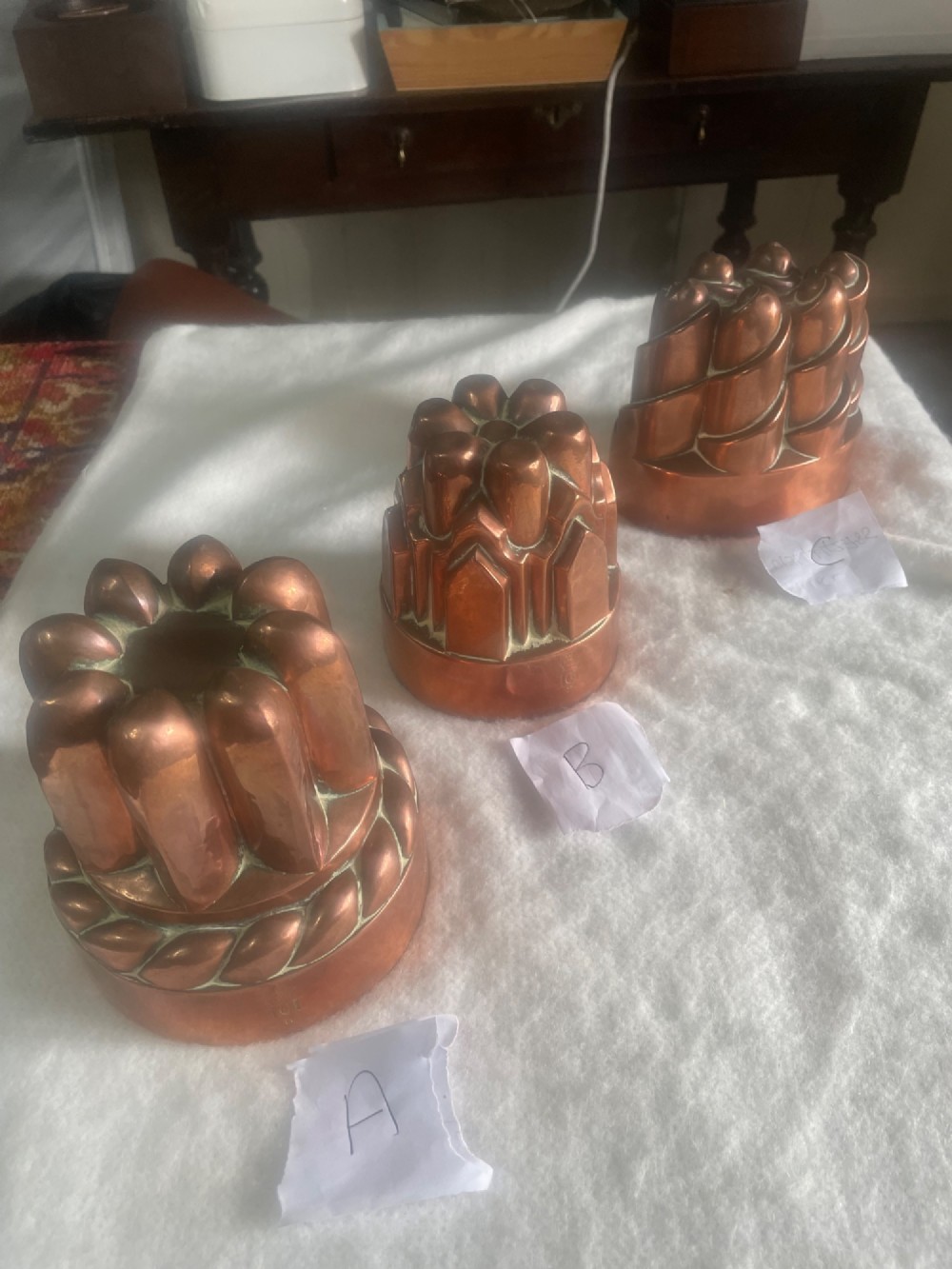 A set of three Victorian copper jelly moulds featuring fluted, architectural, and spiral forms. View II