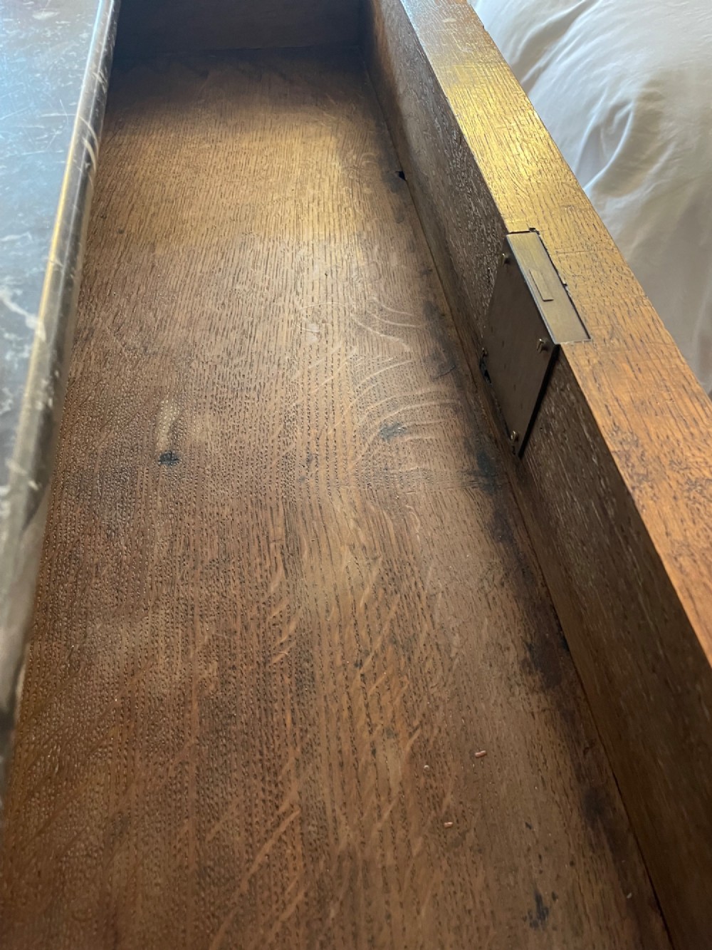 A 19th-century French Louis Philippe mahogany chest of drawers with a dark marble top, pull-out brushing slide, and brass keyhole escutcheons. View VI