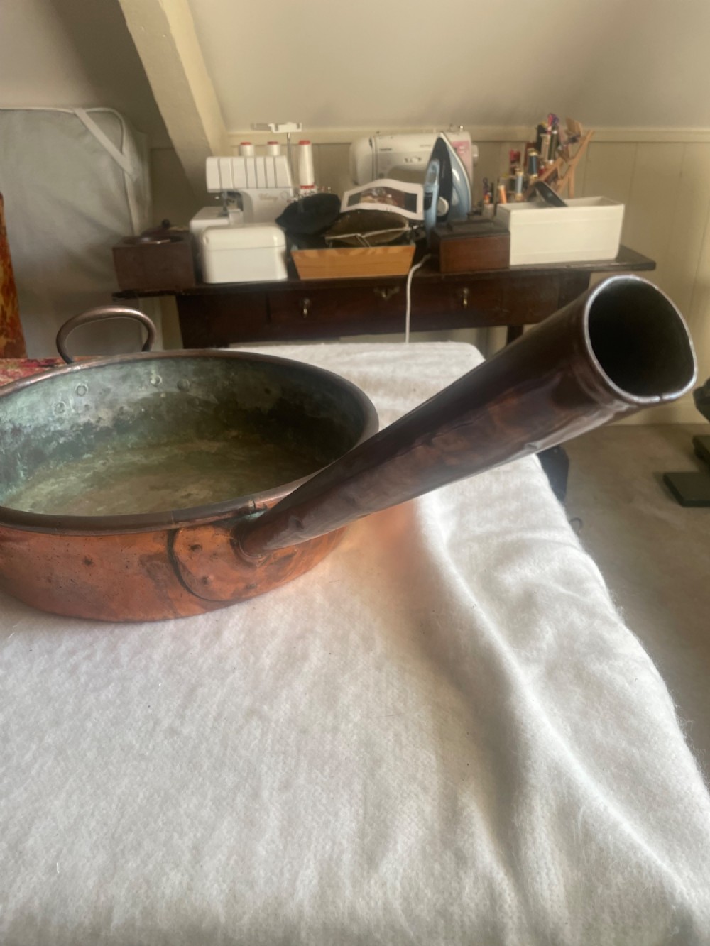 A large antique copper cooking pan with a long tubular handle, a secondary riveted loop handle, and a patinated interior. View II