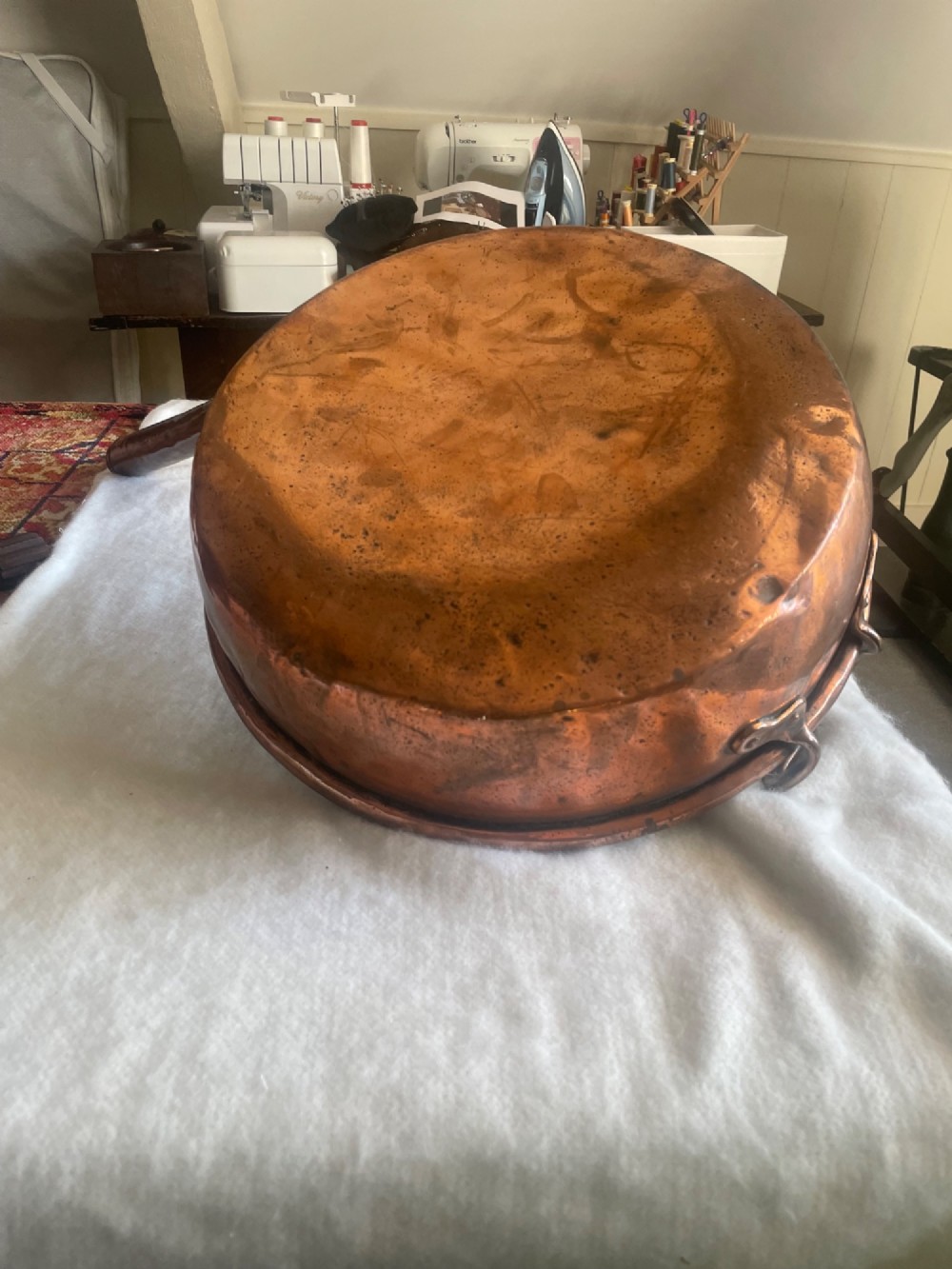 A large antique copper cooking pan with a long tubular handle, a secondary riveted loop handle, and a patinated interior. View III